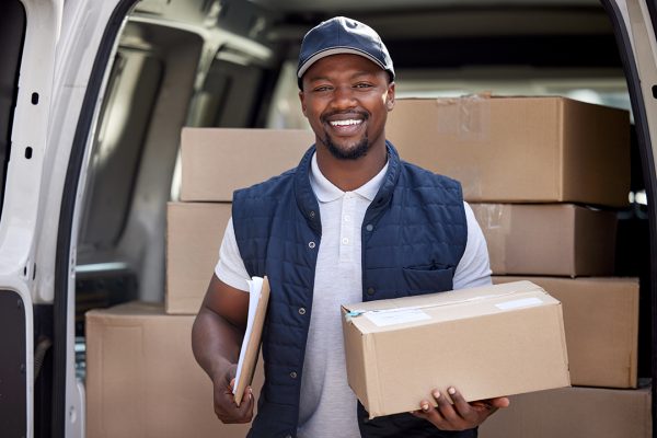 Shot of a delivery man standing by his van.